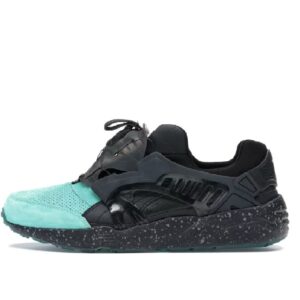 Une sneaker noire et turquoise avec semelle mouchetée isolée sur fond blanc